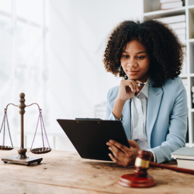 African American lawyer reviewing documents and legal scales