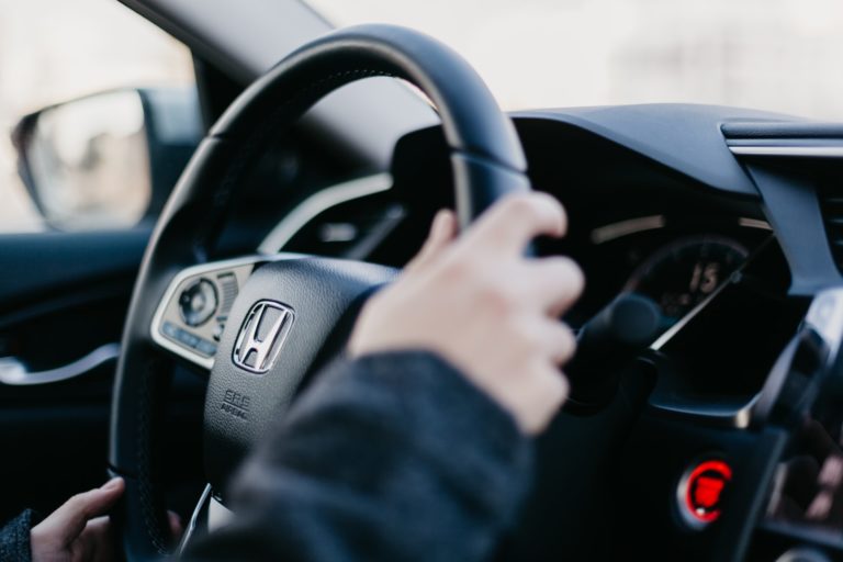 a hand holding a steering wheel